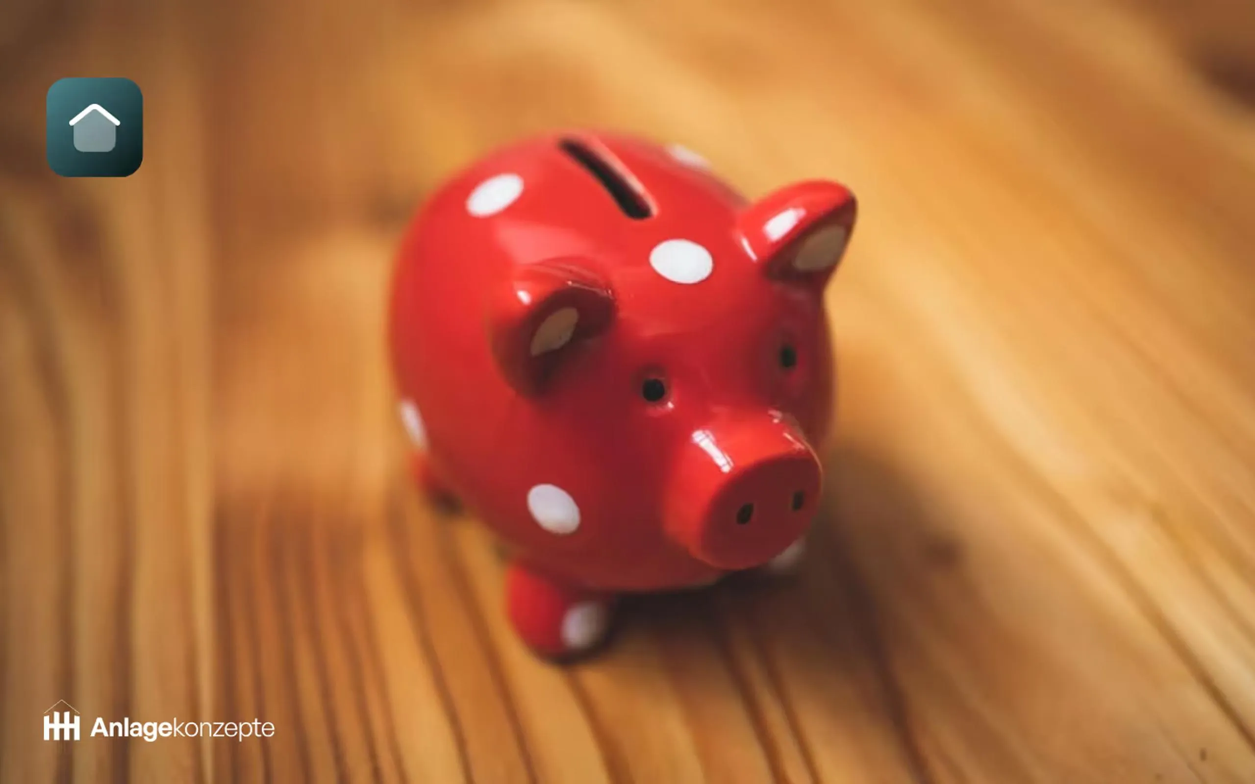 Rotes Sparschwein auf einem Holztisch als Symbol für Steuern sparen bei hohem Einkommen